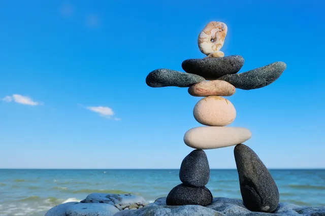 A rock sculpture of balanced rocks on the beach.